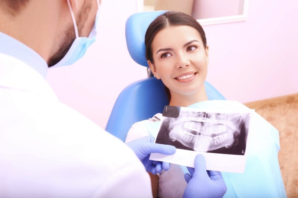 Male dentist talking to female patient